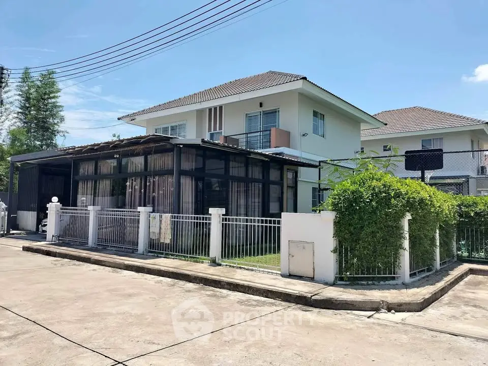 Charming two-story house with lush greenery and modern design in a serene neighborhood.