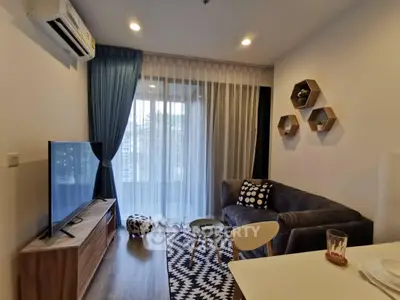 Modern living room with stylish decor, cozy sofa, and large TV, perfect for relaxation and entertainment.