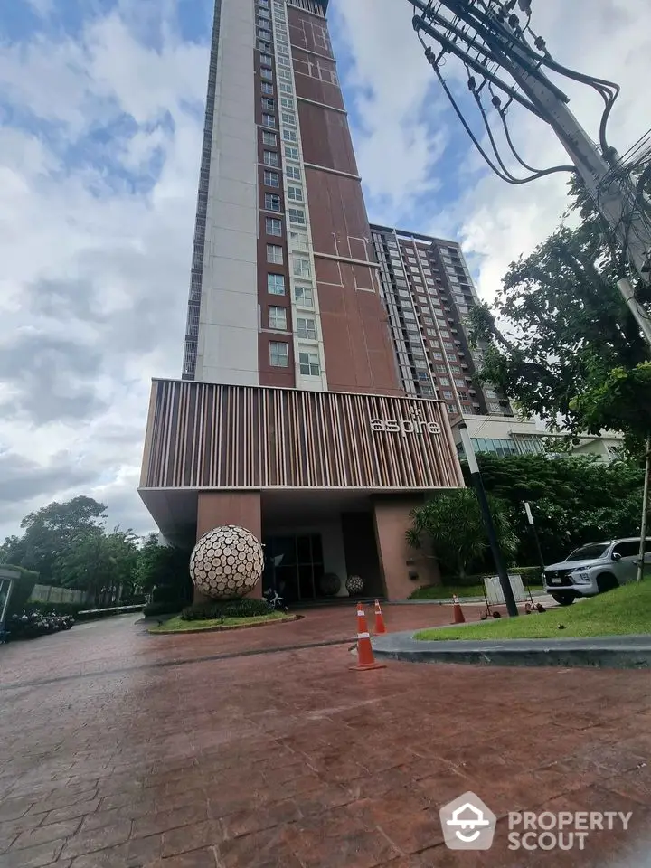 Modern high-rise building with stylish entrance and landscaped surroundings.