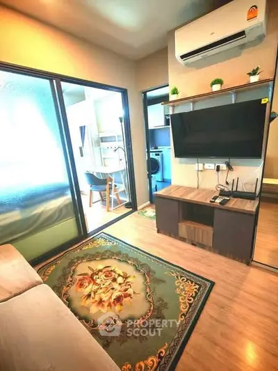 Cozy living room with modern decor and air conditioning, featuring a stylish rug and open view to kitchen area.