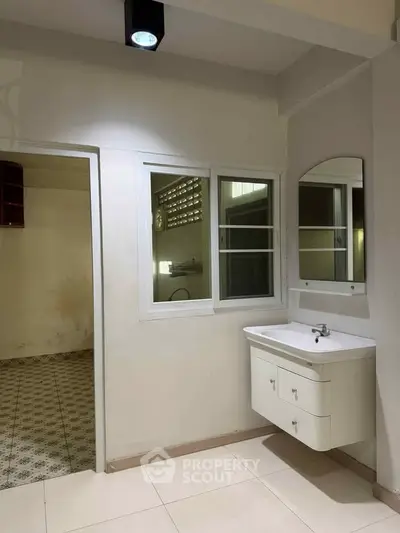 Spacious bathroom with modern sink and large window, perfect for natural light.