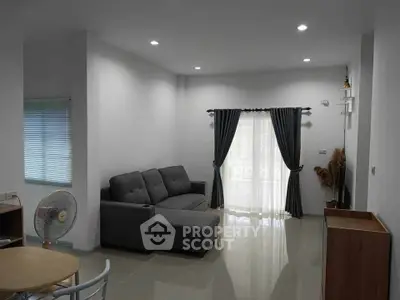 Modern living room with sleek grey sofa and elegant curtains, perfect for relaxation.