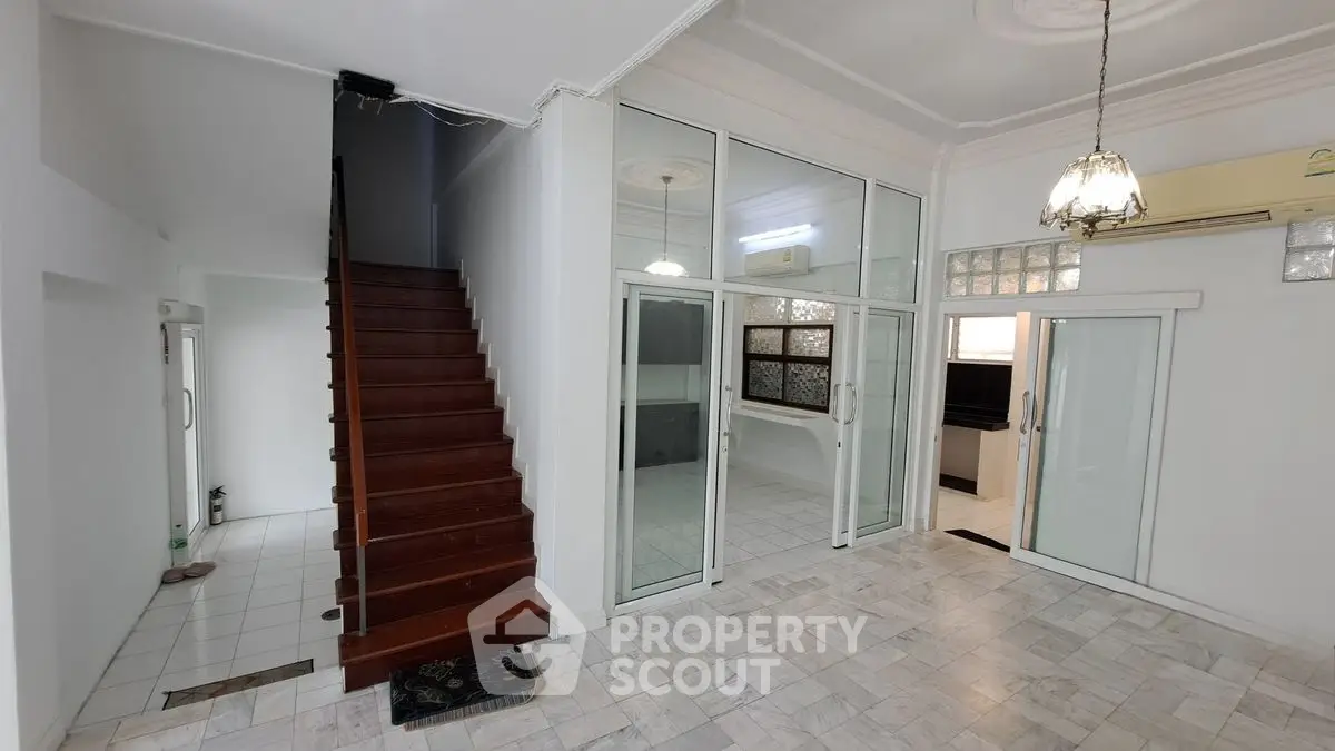 Spacious interior with elegant staircase and modern glass doors