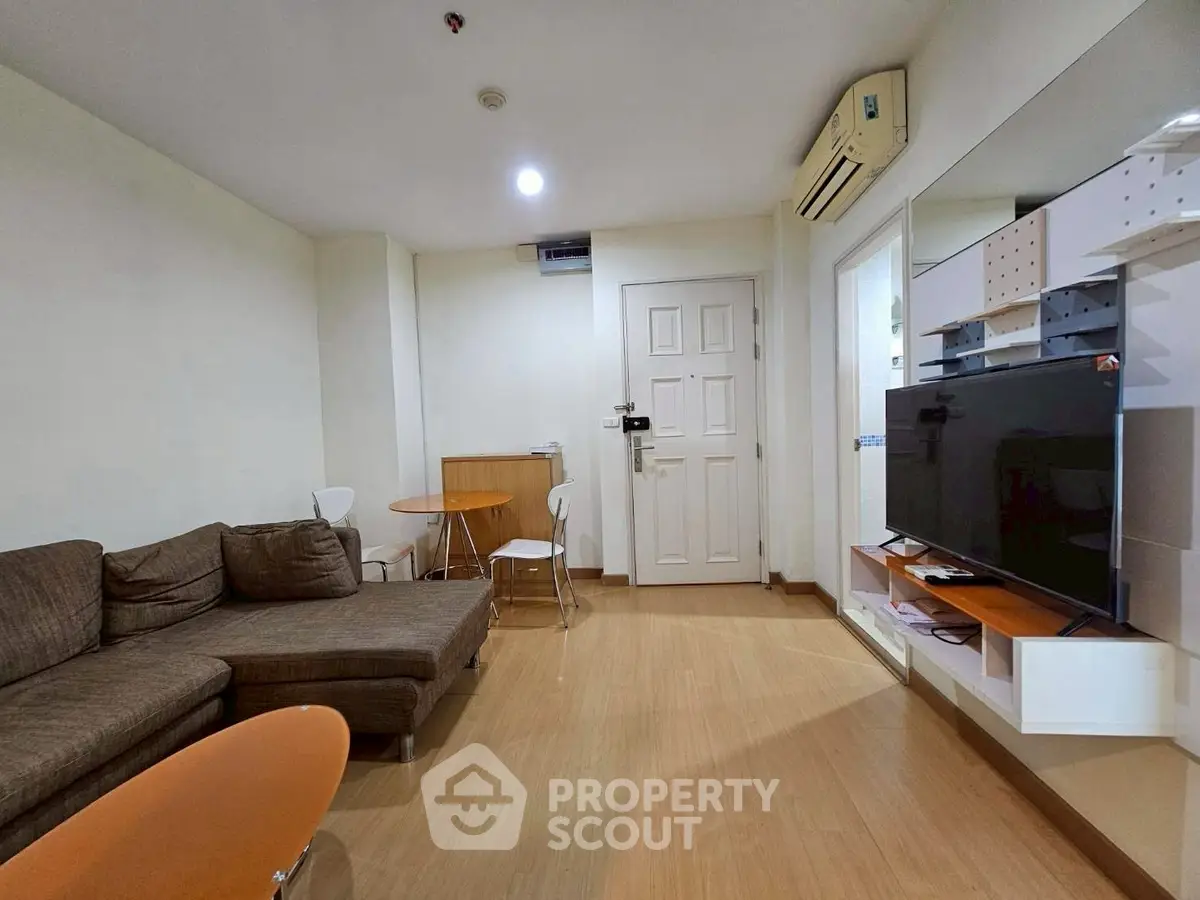 Modern living room with cozy sectional sofa and wall-mounted TV in a stylish apartment.