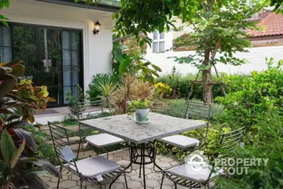 Charming garden patio with elegant outdoor dining set and lush greenery