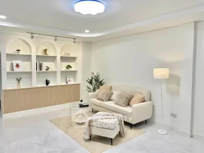 Elegant living room with modern decor, featuring a cozy sofa, stylish shelving, and soft lighting for a welcoming ambiance.