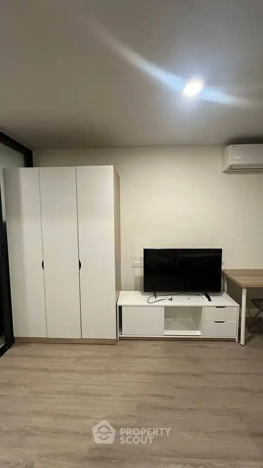 Modern living room with sleek furniture and TV setup, perfect for cozy urban living.