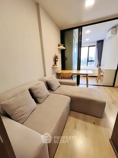 Modern apartment with cozy living room and bedroom view, featuring stylish furniture and natural light.