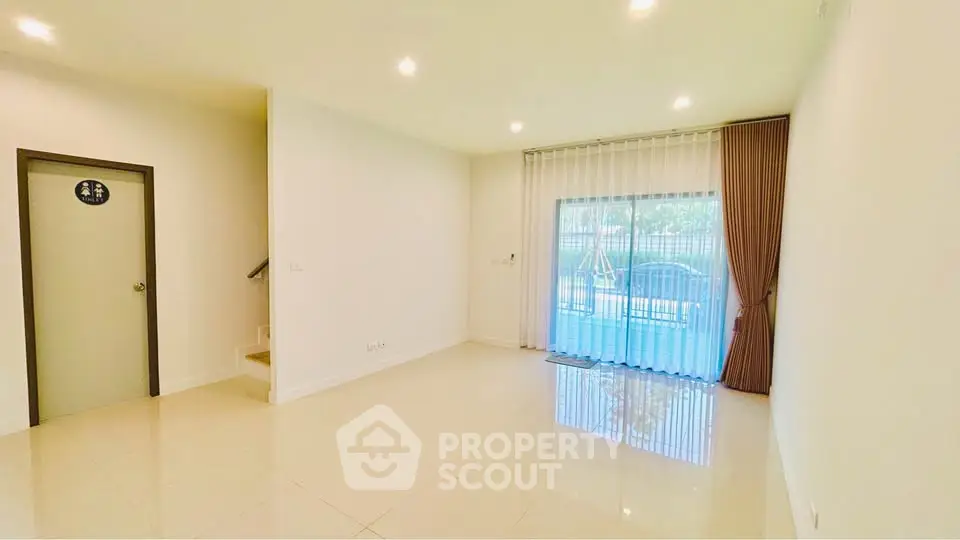 Spacious living room with large window and elegant curtains in modern home