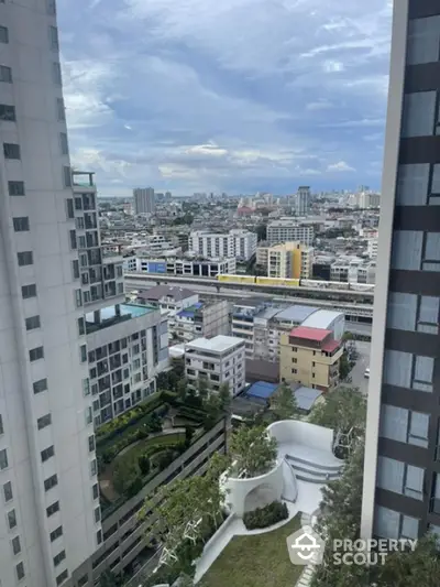 Stunning cityscape view from high-rise building balcony with lush greenery and urban skyline.