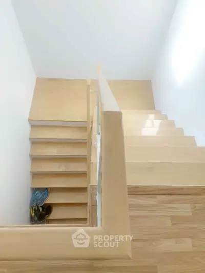 Modern wooden staircase with minimalist design and natural light.