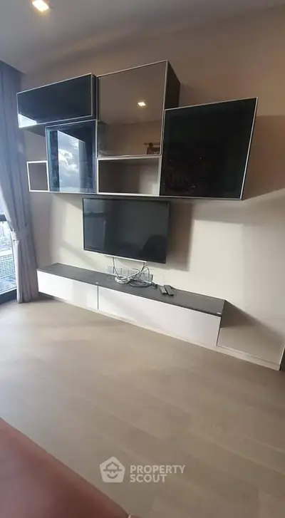 Modern living room with stylish wall-mounted TV and sleek storage units.