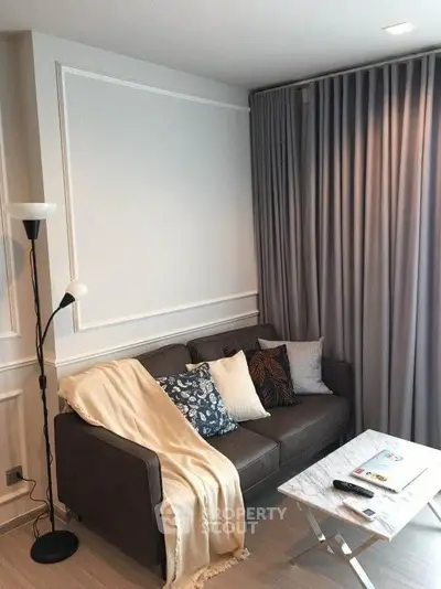Cozy living room with modern decor, featuring a comfortable sofa, stylish floor lamp, and elegant curtains.