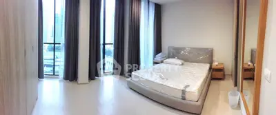 Spacious modern bedroom with large windows and city view