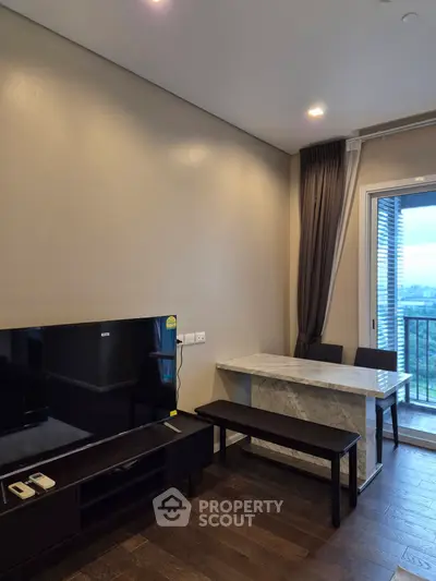 Modern living room with TV, marble table, and balcony view in stylish apartment.