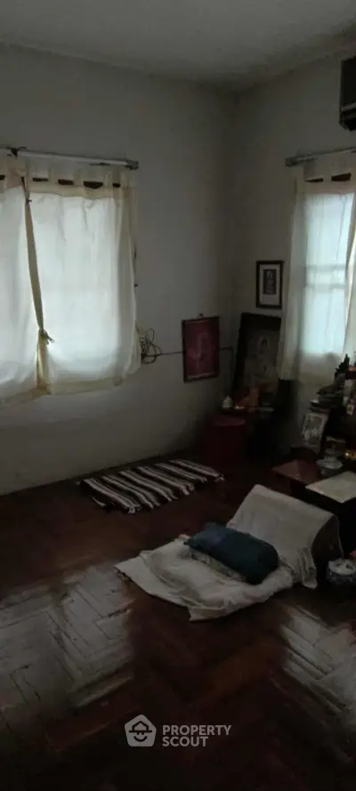 Cozy room with wooden floors and soft lighting, perfect for meditation or relaxation.