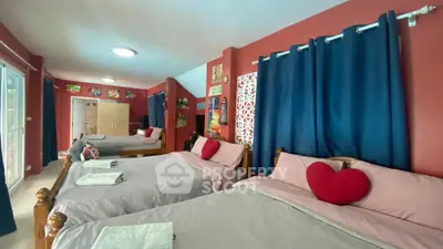 Spacious bedroom with multiple beds and vibrant decor, ideal for family or group stays.