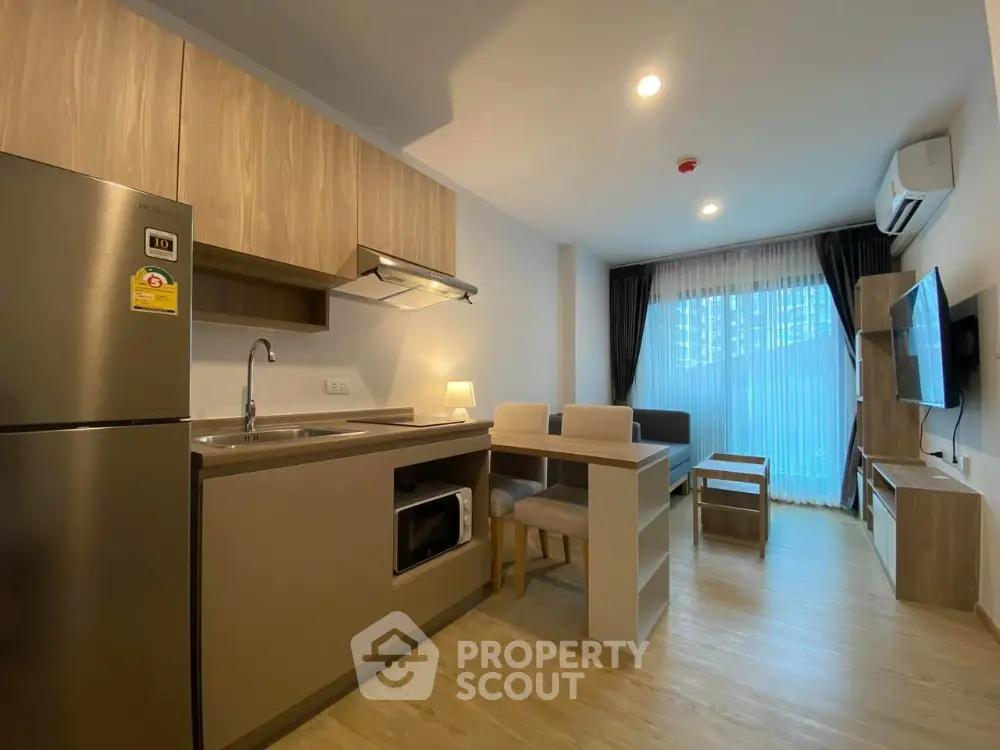 Modern open-layout kitchen and living area with sleek design and natural light.
