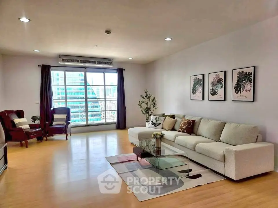 Spacious modern living room with large windows and city view, featuring elegant decor and comfortable seating.