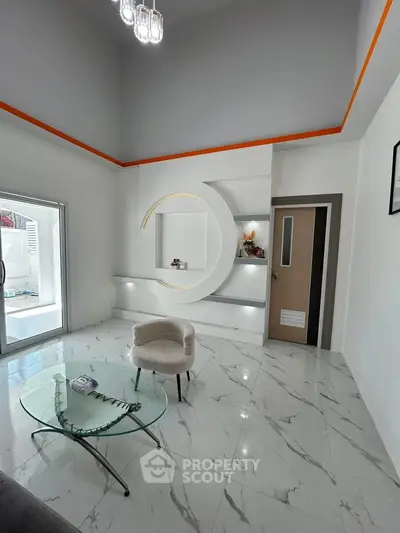 Modern living room with elegant decor and marble flooring, featuring a unique circular wall design and glass coffee table.