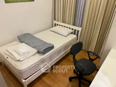 Cozy bedroom with single bed, desk, and chair, perfect for a student or minimalist living.