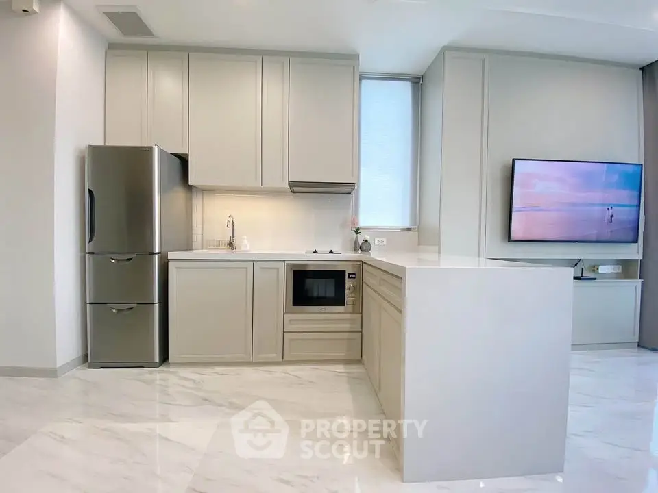 Modern kitchen with sleek cabinetry and integrated appliances in a bright, open space.