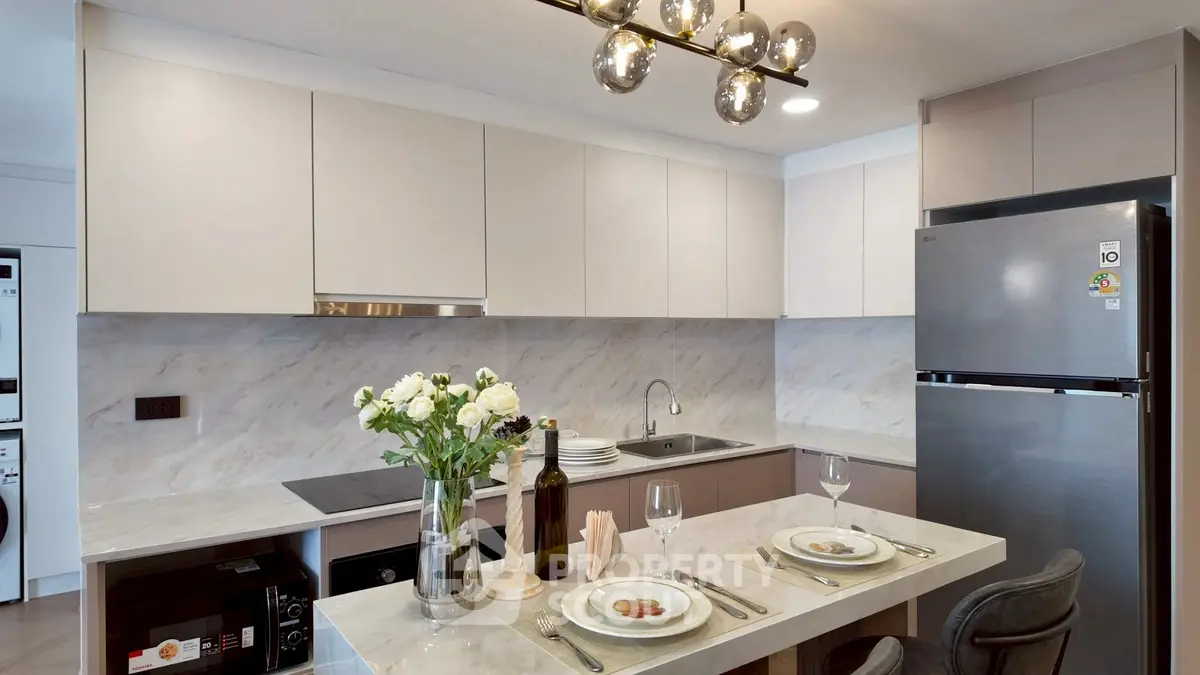 Modern kitchen with sleek cabinetry, marble countertops, and elegant lighting, perfect for culinary enthusiasts.