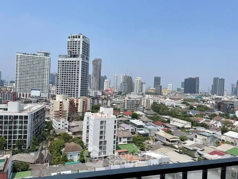 Stunning cityscape view from a high-rise balcony showcasing urban skyline and residential area.