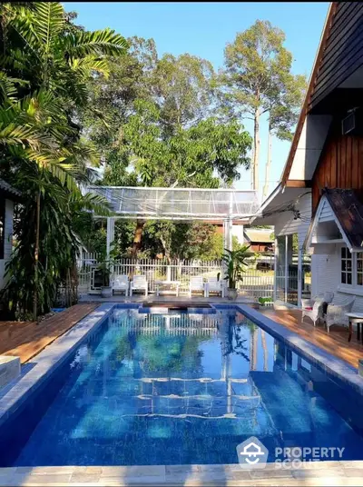 Stunning backyard pool with lush greenery and modern design, perfect for relaxation and entertainment.