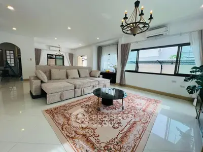 Spacious living room with elegant chandelier and large windows in a modern home.