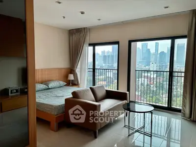 Modern bedroom with city view, featuring a cozy sofa and large windows in a high-rise apartment.