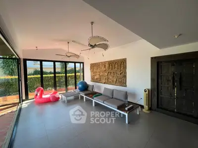 Spacious living room with modern decor and large windows overlooking garden