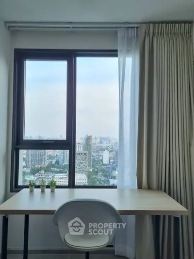 Modern study room with city view from large window, featuring a sleek desk and chair.