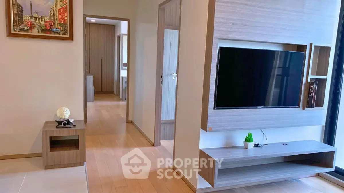 Modern living room with sleek TV unit and wooden flooring in a stylish apartment.