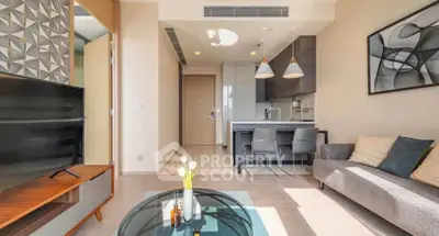 Modern living room with stylish decor and open kitchen layout, featuring contemporary furniture and natural light.