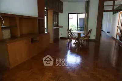 Spacious living room with wooden flooring and dining area, perfect for family gatherings.