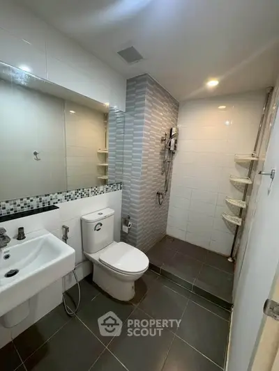 Modern bathroom with sleek design, featuring a walk-in shower and contemporary fixtures.