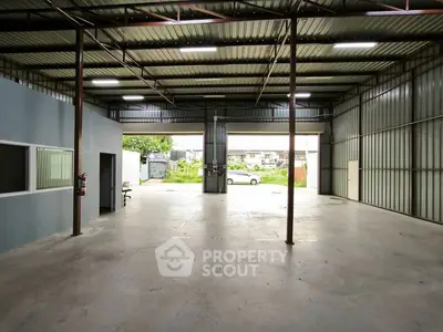 Spacious industrial warehouse with high ceilings and ample natural light.