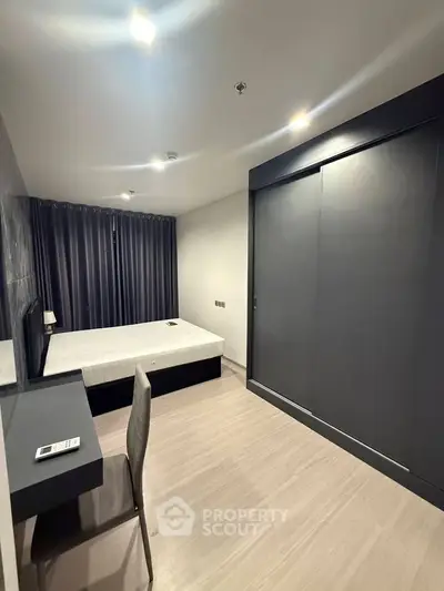Modern minimalist bedroom with sleek furniture and ample natural light.