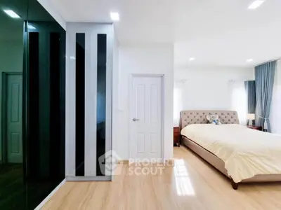 Spacious modern bedroom with elegant decor and ample natural light