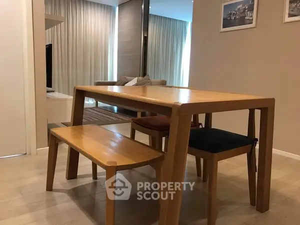 Modern dining area with wooden table and chairs in stylish apartment.