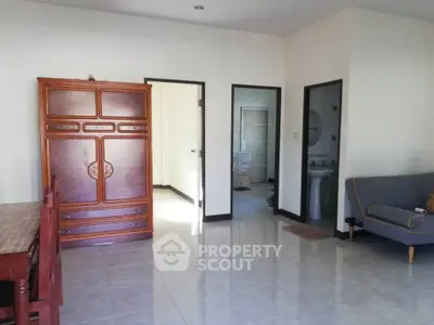 Spacious living area with wooden furniture and tiled flooring
