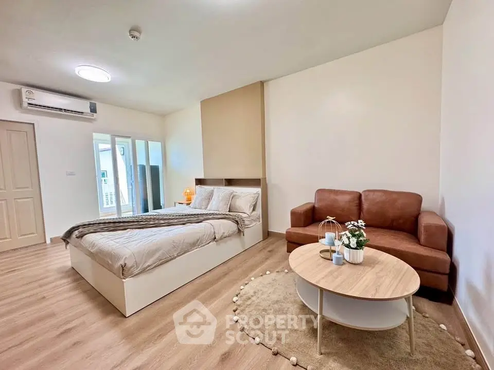 Spacious modern bedroom with cozy seating area and stylish decor