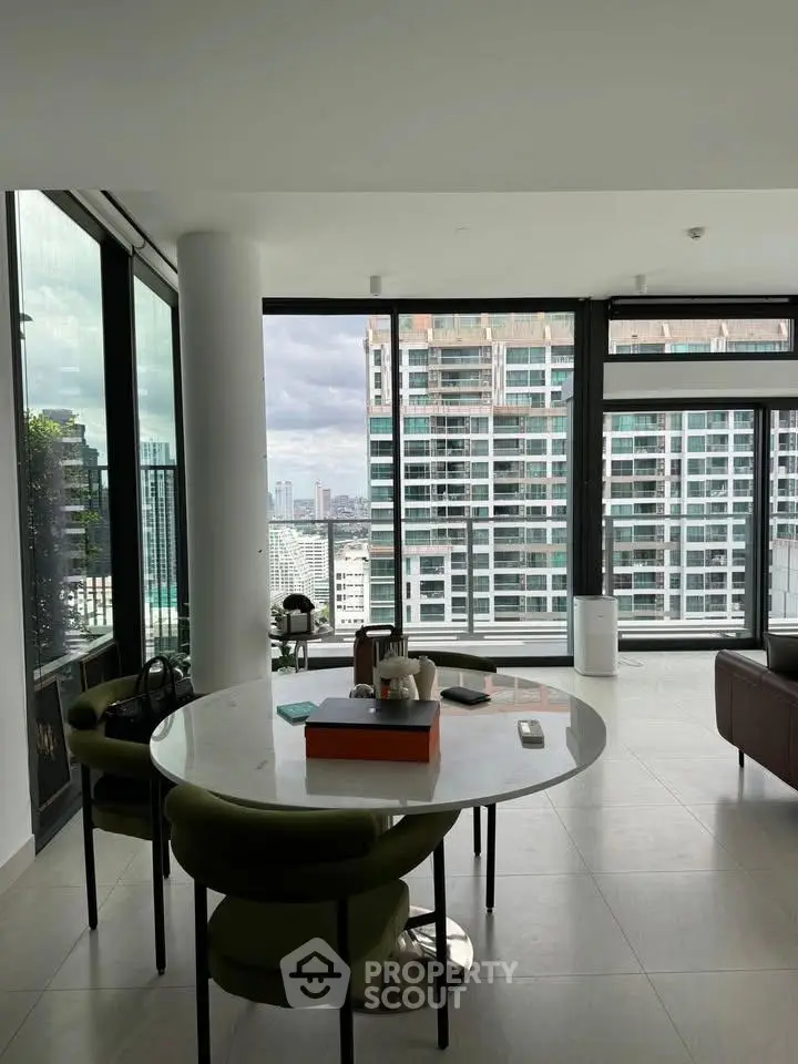 Modern living room with panoramic city view and stylish furniture in high-rise apartment.