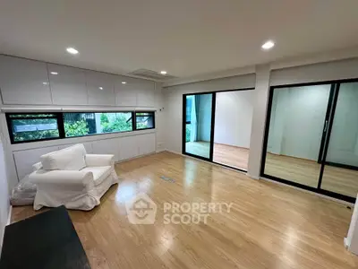 Spacious modern living room with large windows and wooden flooring