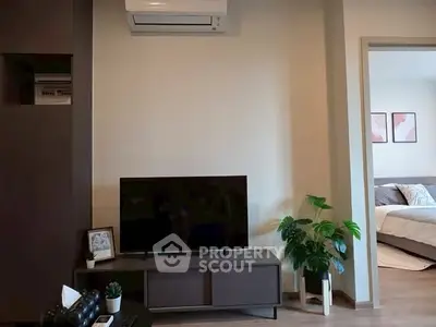 Modern living room with air conditioning and view into cozy bedroom
