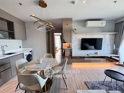 Modern living room with stylish decor, open kitchen, and elegant dining area in a contemporary apartment.