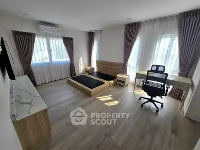 Spacious bedroom with modern furniture and large windows for natural light