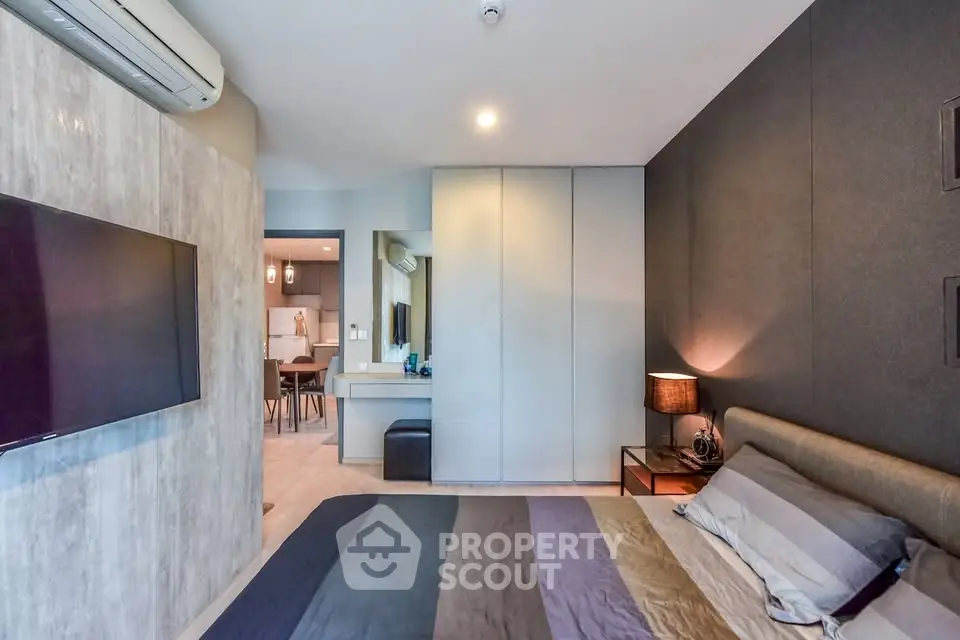 Modern bedroom with stylish decor and wall-mounted TV in a contemporary apartment.