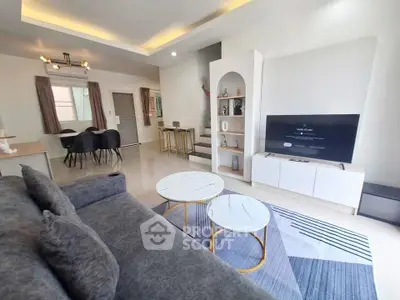 Modern living room with stylish decor and open layout, featuring a cozy sofa and sleek TV unit.